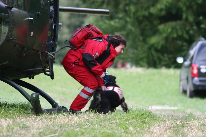 Rettungshundeführerin und Rettungshund steigen aus Hubschrauber