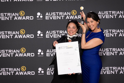 Zwei Damen vor Leinwand mit dem Preis beim Austrian Event Award