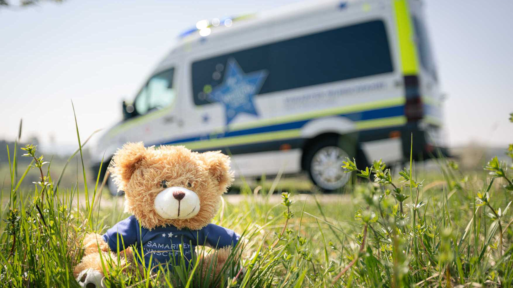 Wunschfahrt-Auto mit Teddybären im Vordergrund