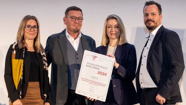 Vier Personen halten ein Zertifikat für Grundzertifizierung 2024 in der Hand.