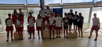 Gruppenfoto von Rettungsschwimmern in Sportbekleidung, die posieren.