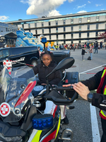 Ein Mädchen sitzt auf einem Motorrad der Polizei.