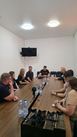 Gruppengespräch in einem Konferenzraum mit mehreren Personen am Tisch.