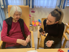 Eine ältere Frau und eine jüngere Person basteln gemeinsam.