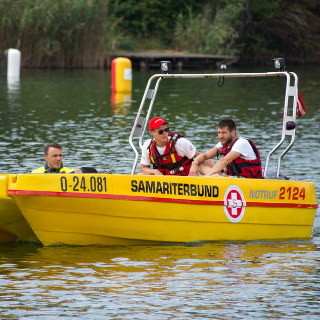 Gelbes Rettungsboot im Wasser mit zwei Rettungsschwimmern an Board