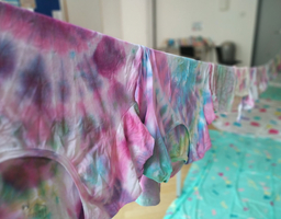 Die bunten Batik-Tshirts trocknen auf einer Wäscheleine