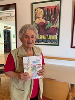 Eine ältere Frau hält ein Buch über das Burgenland in der Hand.