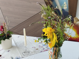 Ein bunter Blumenstrauß in einer Vase steht auf einem Tisch.