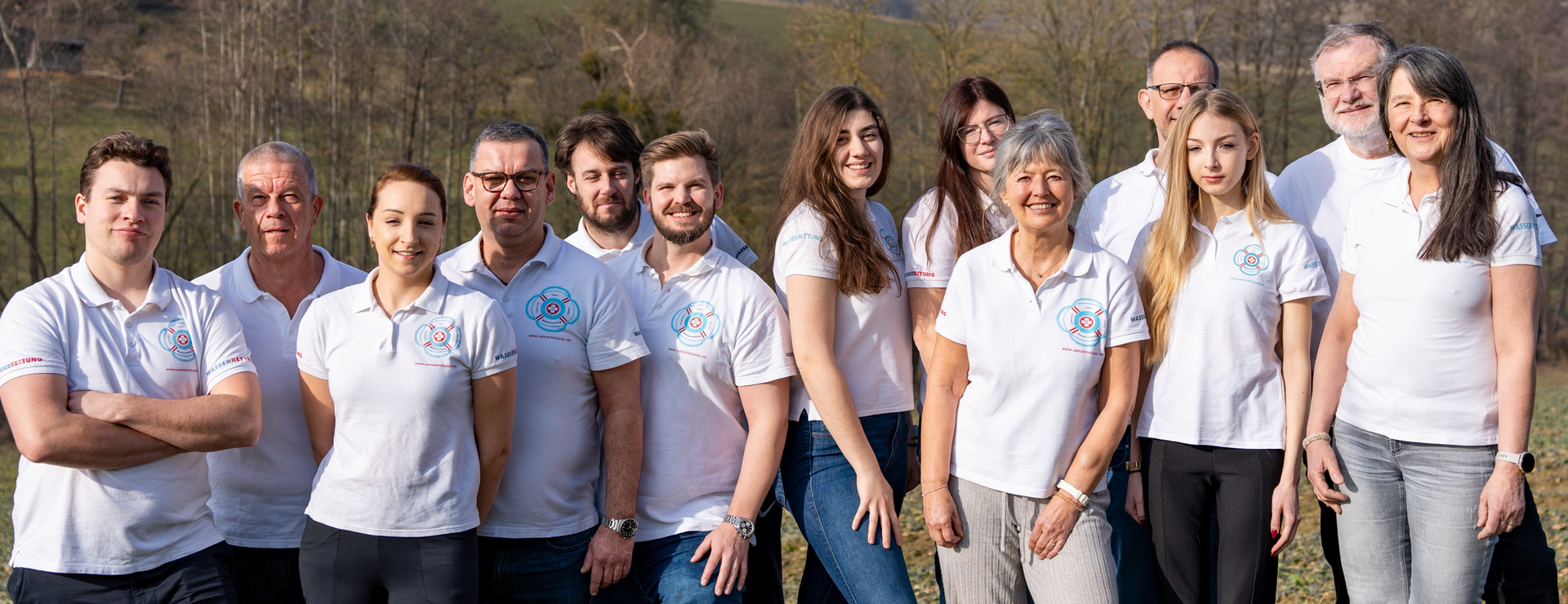 Gruppe von Personen in weißen T-Shirts steht in der Natur zusammen.