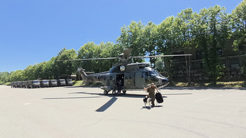 Ein Soldat mit Hund verlässt einen Hubschrauber 