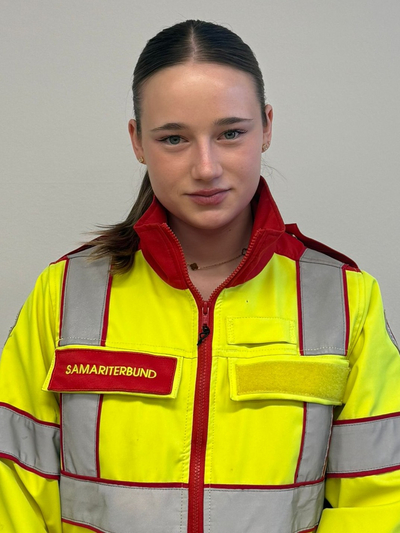 Eine junge Frau in einer leuchtend gelben Rettungsweste des Samariterbundes.