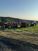 Feuerwehrfahrzeuge und Einsatzkräfte auf einem Feld.