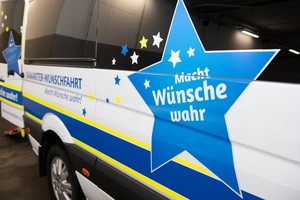 Samariter-Wunschfahrt: Macht Wünsche wahr! Schriftzug auf einem Fahrzeug.