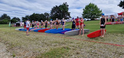 Gruppierung von Schwimmern mit Surfbrettern vor einem Wettkampf.