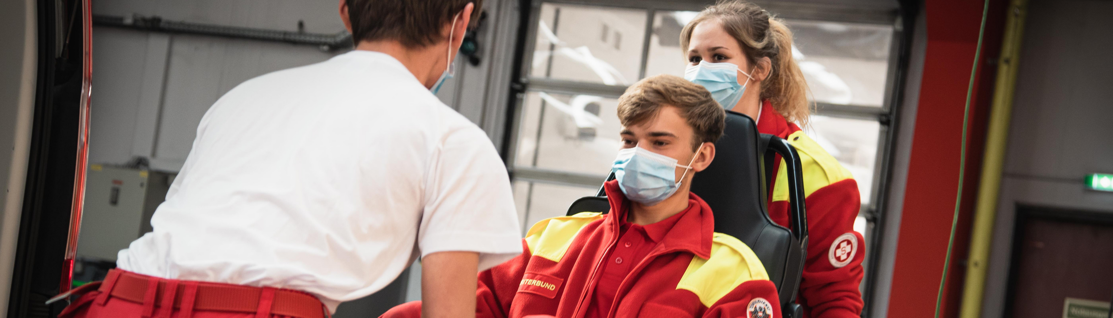 2 Samariter tragen einen dritten am Tragesessel