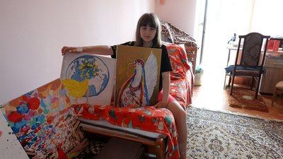 Ukrainisches Kind zeigt ihre gemalten Bilder