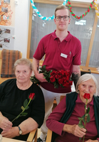 Drei Personen halten Rosen in einer festlichen Umgebung.