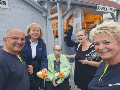 Fünf Personen posieren zusammen und halten Snacks in den Händen.