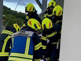 Feuerwehrleute tragen eine Person die Treppe hinunter.