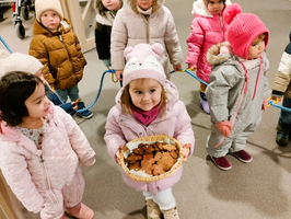 Kinder in warmer Kleidung halten einen Teller mit Keksen.