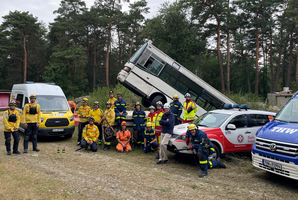 Rettungskräfte stehen vor einem umgestürzten Bus und Einsatzfahrzeugen.
