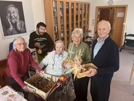 Fünf Personen in einem Raum stellen handgefertigte Geschenkartikel vor.