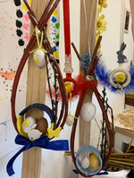 Osterdekoration mit bunten Eiern und niedlichen Figuren an Zweigen.