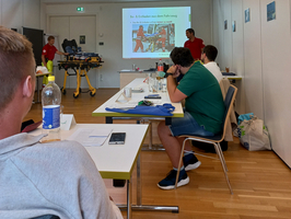 Ein Präsentationsraum mit Personen, die Informationen über das Laden und Entladen geben.