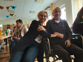 Eine Frau umarmt einen älteren Mann in einem Gemeinschaftsraum.