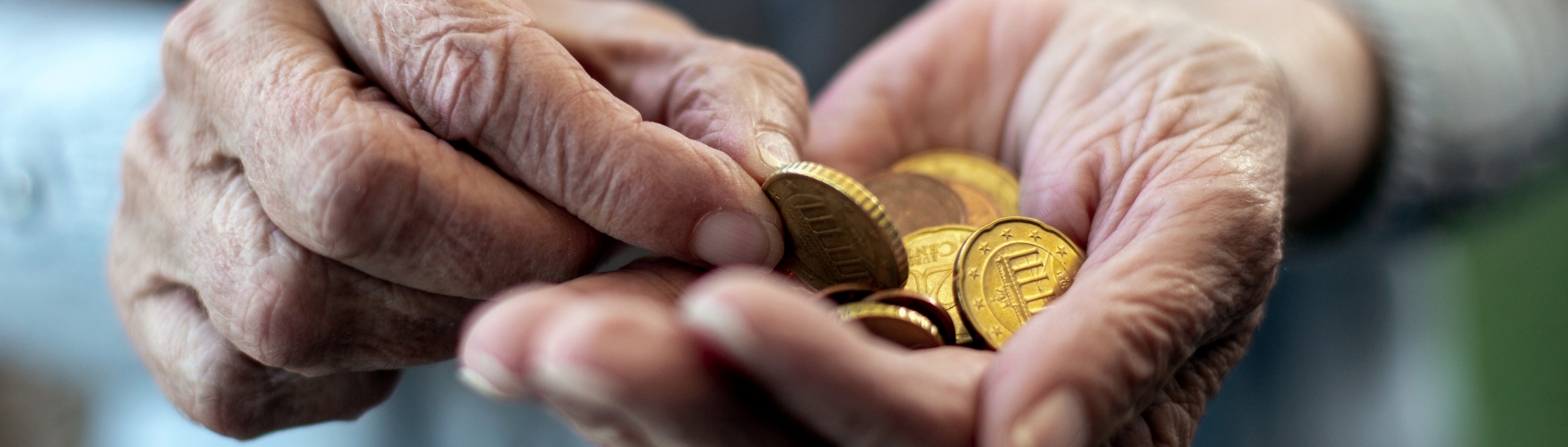 Ein ältere Person zählt Münzen in die offene Hand