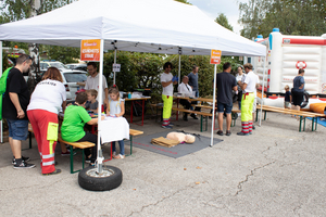 Das Bild zeigt einen Erste-Hilfe-Stand mit Lernenden und Ausbildern.