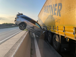 Schwerer Verkehrsunfall: Ein Pkw steckt teilweise zwischen Lkw und Leitplanke fest.
