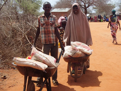 Kenianisches Ehepaar transportiert Hilfsgüter in Schubkarren