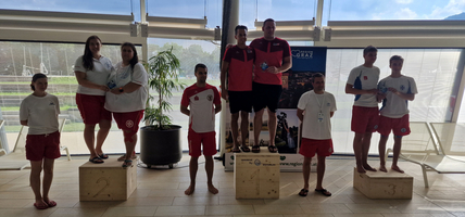 Mehrere Schwimmer stehen auf dem Podium und halten Medaillen in den Händen.