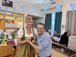Zwei Personen tanzen fröhlich in einem festlich dekorierten Raum.