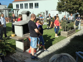 Eine Gruppe von Menschen steht im Freien und beobachtet eine Veranstaltung.