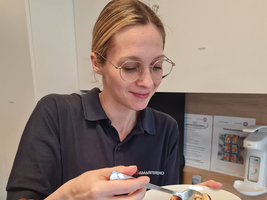 Eine Frau mit Brille genießt einen Dessert in einer Schüssel.