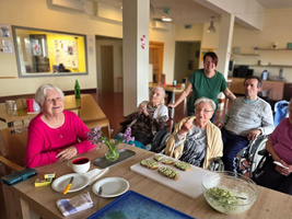 Eine Gruppe von Senioren sitzt zusammen und genießt gemeinsam Essen und Geselligkeit.