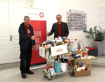 Georg Jelenko, Leiter der Sozialmärkte des Samariterbund Wien, und Georg Papai, Bezirksvorsteher von Floridsdorf, freuen sich über ein randvolles Samariterwagerl.