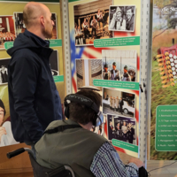 Zwei Personen betrachten eine informative Ausstellung über Musik und Kultur.