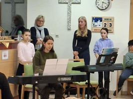 Kinder führen ein Konzert am Keyboard in einem festlichen Raum auf.