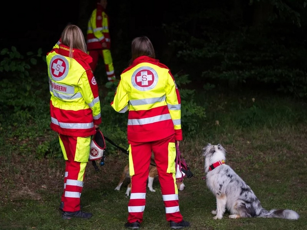 Zwei Rettungshundeführerinnen und ein Rettungshund bei einer Übung