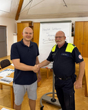 Zwei Männer schütteln sich die Hände in einem Besprechungsraum.