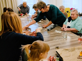Mehrere Personen backen gemeinsam an einem Tisch in einer freundlichen Umgebung.
