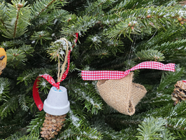 Ein Weihnachtsbaum mit verschiedenen handgemachten Ornamenten und Schnee.