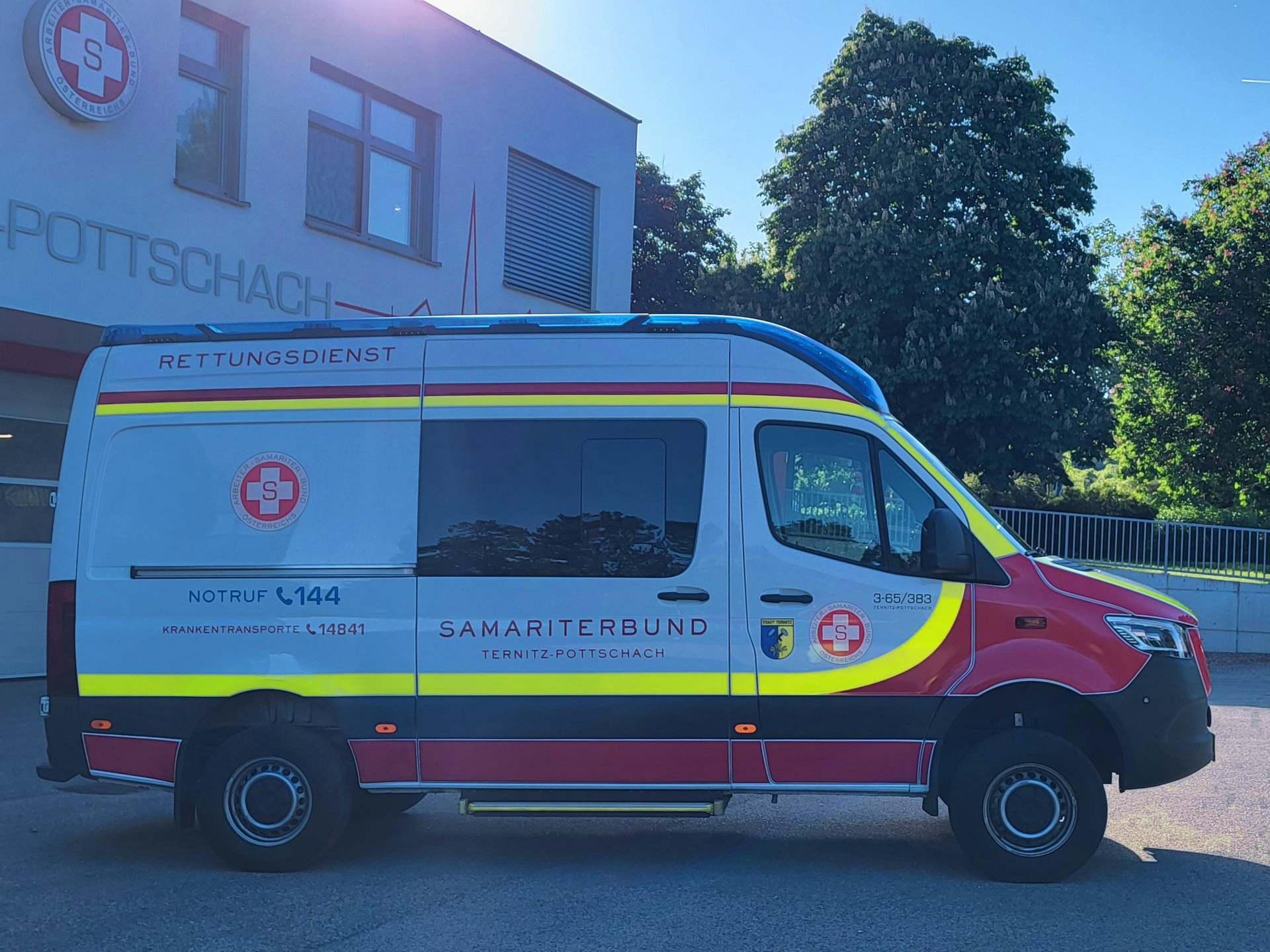 Rettungsdienstfahrzeug des Samariterbundes vor einem Gebäude in Pottschach.