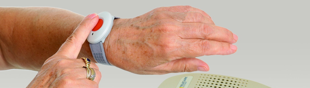 Hand mit Uhr und Gerät für Heimnotruf