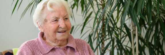 Bewohnerin eines Pflegekompetenzzentrums mit zufriedenem Gesichtsausdruck