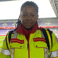 Eine Person in leuchtend gelber Sicherheitskleidung steht im Stadion.