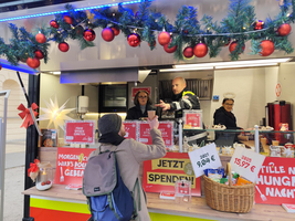 Eine Frau bekommt einen Becher Punsch am Foodtruck des Samariterbundes Wien